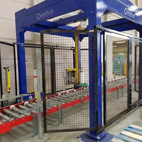 Automatisierte Verpackungsmaschine mit Netzschutz und Förderband.