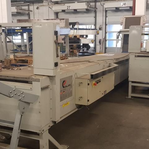 Eine große industrielle Maschine in einer Werkstatt mit mehreren Arbeitsstationen.