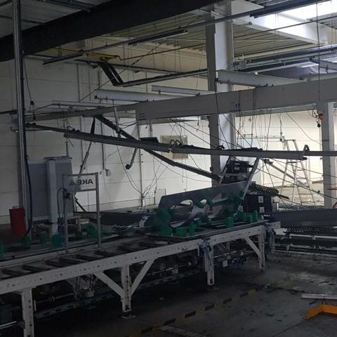 Leerer Raum mit Maschinen und Förderbändern in einer industriellen Umgebung.