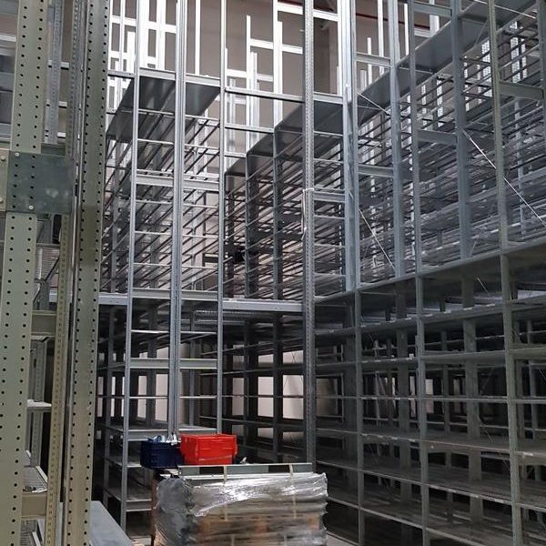 Lagerregale in einem großen Raum, teilweise gefüllt mit Materialien und Kisten.