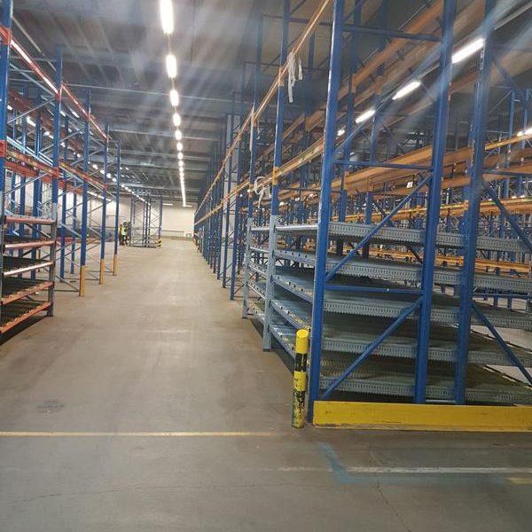 Leeres Lager mit hohen Regalen in blauen und orangefarbenen Farben.