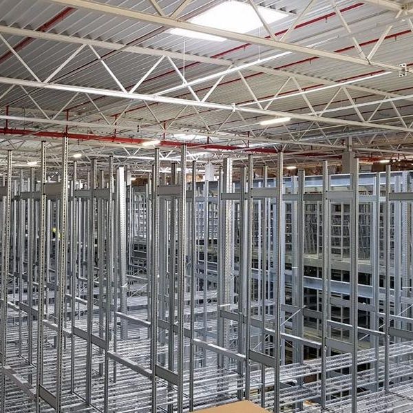 Halleninterieur mit Stahlgerüsten und freiem Raum für Lagerung oder Konstruktion.