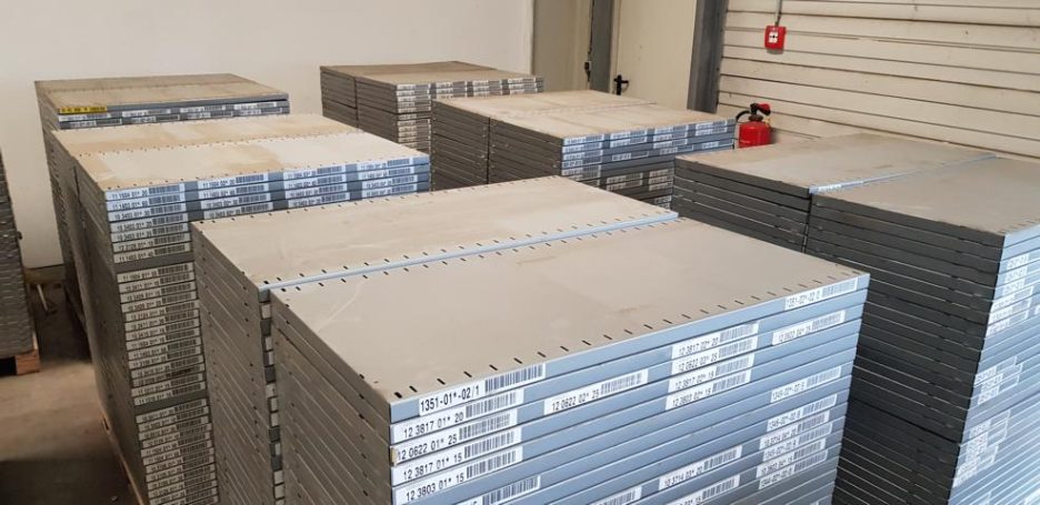 Stapelhaufen von grauen Kisten in einem Lagerraum.