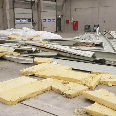 Haufen von beschädigten Materialien, darunter Metall und Isolierplatten, auf dem Boden.