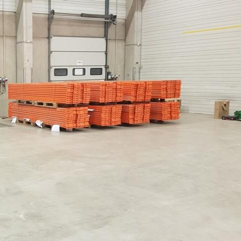 Orange Palettenstapel in einem großen, hellen Lagerraum.