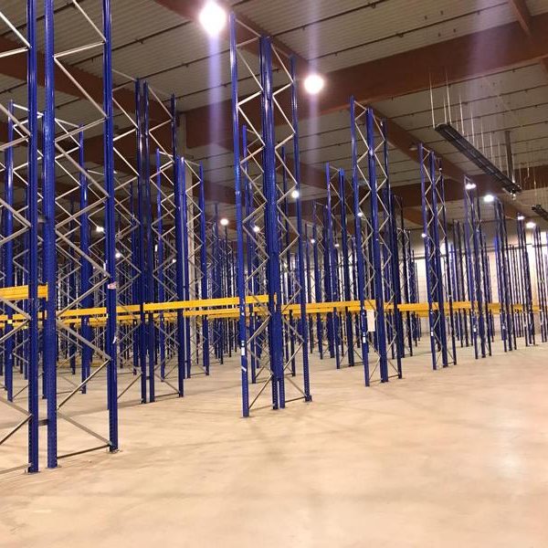 Leere Lagerhalle mit blauen Regalsystemen und gelben Regalträgern.