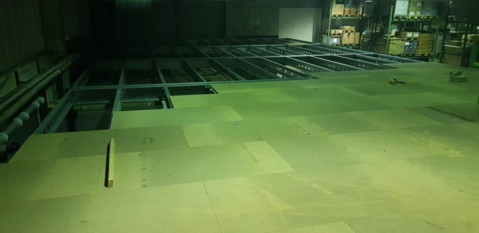 Leere Halle mit großen, Bodenplatten auf einer Lagerebene.