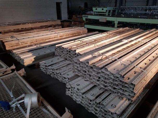 Holzlatten und -balken, ordentlich gestapelt in einer Lagerhalle.