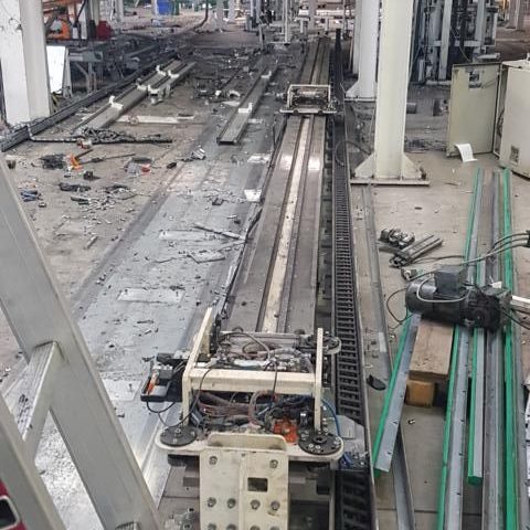 Blick auf eine Produktionslinie mit Maschinen und Fahrwegen in einer Fabrikhalle.