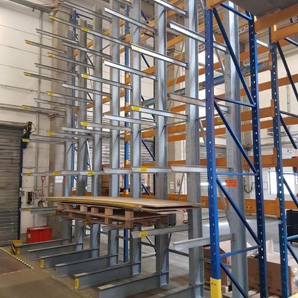 Regalsystem mit Metallsäulen und Holzplatten in einem Lagerraum.