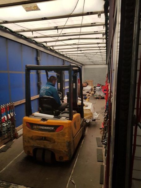 Gabelstaplerfahrer transportiert Waren in einem Lagerraum.