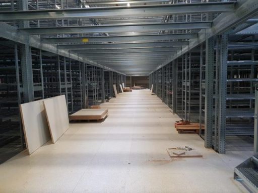 Lange, leere Lagerregale in einem modernen, industriellen Raum.