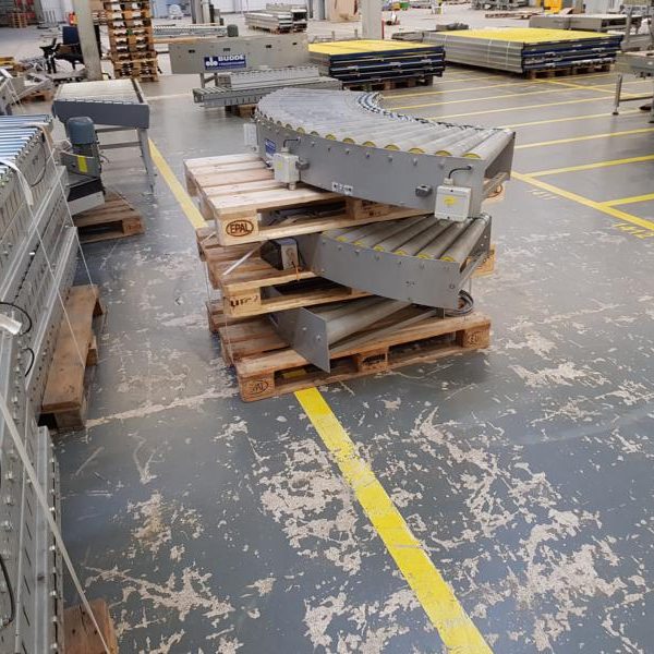 Graue Rampenteile gestapelt auf Holzpaletten in einer Lagerumgebung.