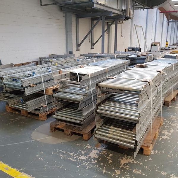 Gestapelte Metallregale auf Paletten in einem Lagerraum.