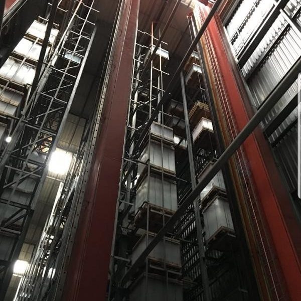 Blick von unten auf eine industrielle Lagerhalle mit zahlreichen Regalreihen.