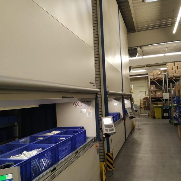 Lagerraum mit automatischen Regalsystemen und blauen Aufbewahrungskisten.
