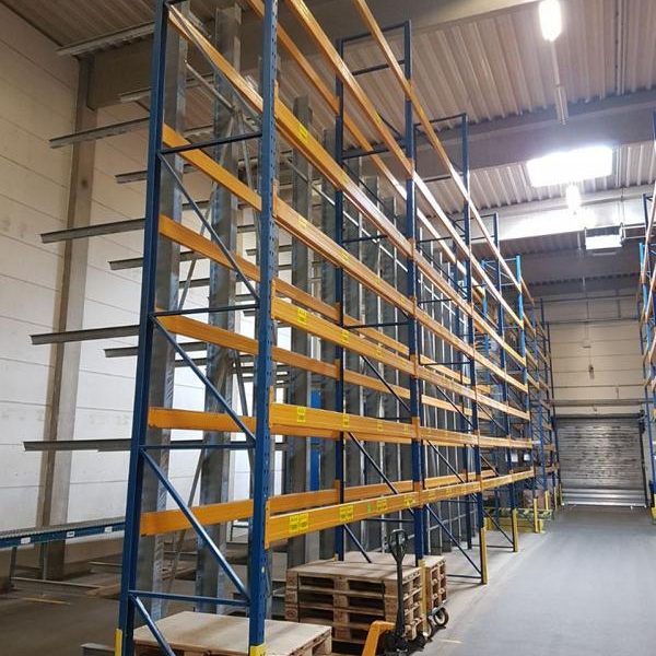 Lagerregale mit blauen Stahlrahmen und gelben Ablagen, Paletten im Vordergrund.
