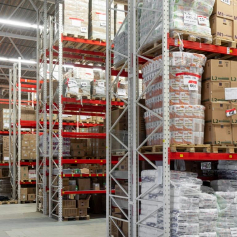 Lagerräume mit hohen Regalen, gefüllt mit Kisten und Verpackungen.