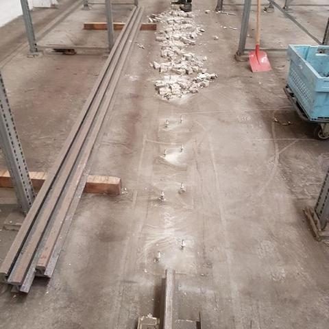 Boden eines Lagerraums mit Metallstangen und verteiltem Baumaterial.