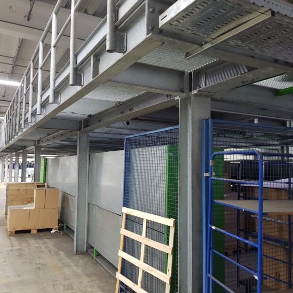 Lagerraum mit Regalen, Holzpaletten und einer erhöhten Plattform.