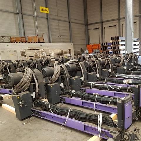 Mehrere große Seilwinden in einem Lager, ordentlich angeordnet auf dem Boden.