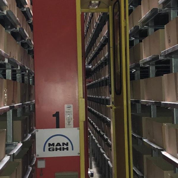 Regal mit vielen Boxen und einem Gabelstapler in einem Lagerbereich.