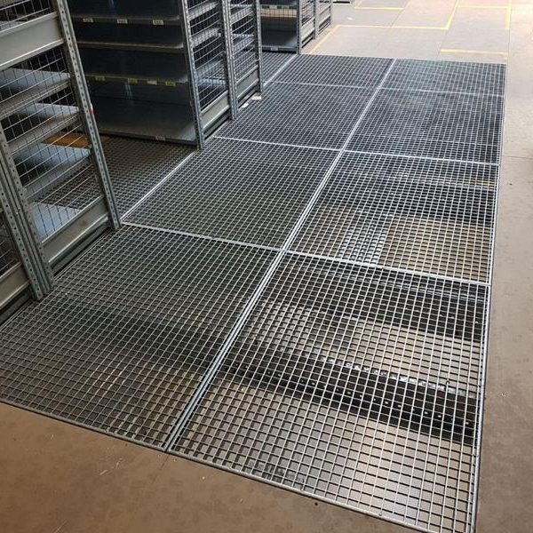 Gitterrostböden in einem Lagerraum mit Regalen.