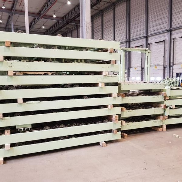 Grüne Holzpaletten gestapelt in einer Lagerhalle.