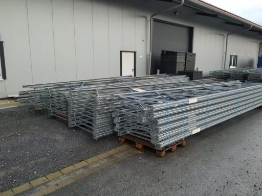 Stapelhaufen von verzinkten Metallplatten auf einem Palettenlagerplatz.