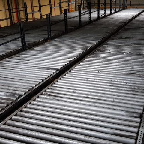 Leere, industrielle Halle mit Metallböden und horizontalen Streben.