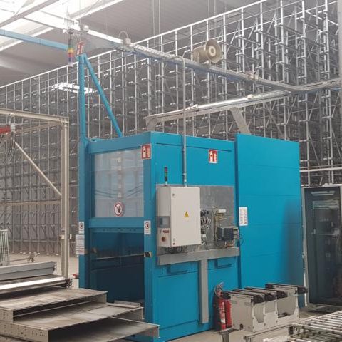 Blaues Maschinenmodul in einer industriellen Umgebung mit Regalen im Hintergrund.