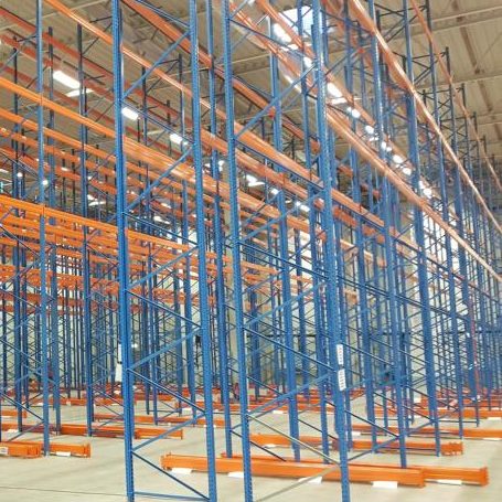 Regalsystem in einem Lager, orangefarbene und blaue Metallregale, leer und ordentlich.