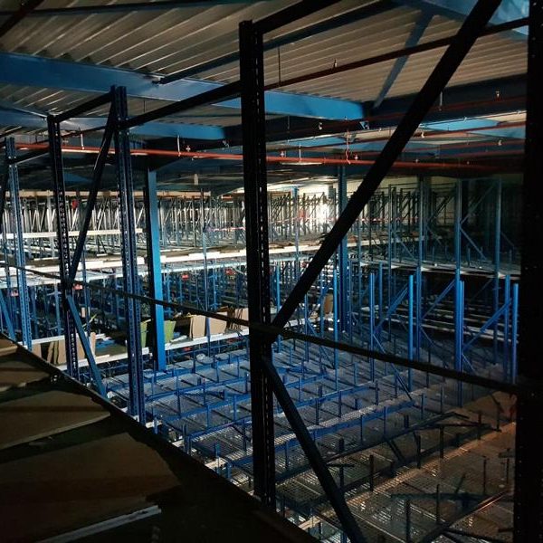 Lagerregale in blauer Farbe, in einem großen, beleuchteten Raum.