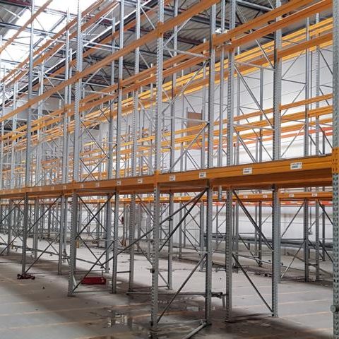 Regalsystem in einem Lager mit orangefarbenen Trägersystemen und freiem Bodenbereich.