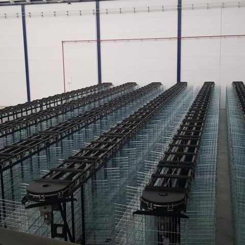 Leere Lagerregale in einer großen, hellen Industriehalle.