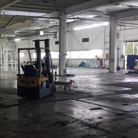 Gabelstapler in einem großen, leeren Lagerraum mit hellem Licht.