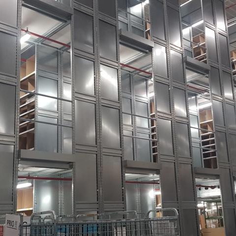 Moderne Gebäudeansicht mit metallischer Fassade und Regalen im Inneren.