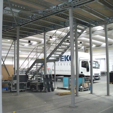 Industriegebäude mit Treppe und Lieferwagen im Hintergrund.