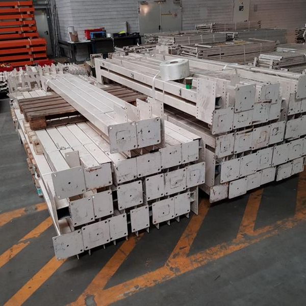 Gestapelte, lackierte Holzlatten auf einem Lagerboden.