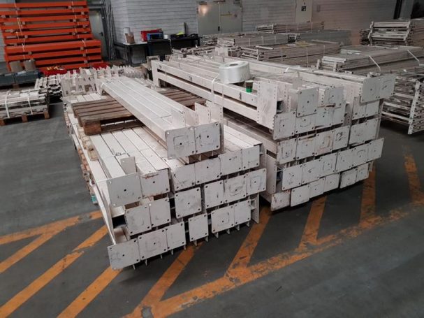 Gestapelte Baustellenmaterialien in einer Lagerhalle.