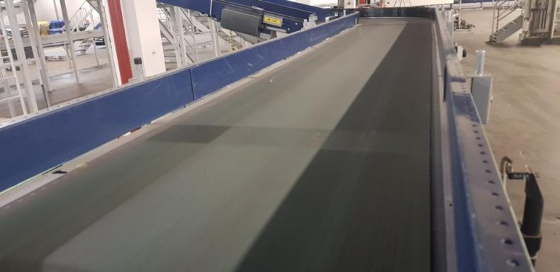 Transportband in einer industriellen Umgebung, mit einem glatten, langen Förderbereich.