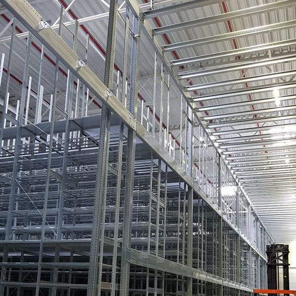 Regalsystem in einer großen Lagerhalle mit hohen Metallgestellen.