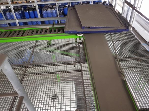 Förderband in einer Produktionsstätte mit grünen und blauen Elementen.