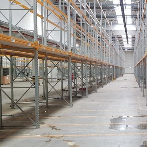 Lagerhalle mit vielen gestapelten Holzpaletten in geordneten Reihen.