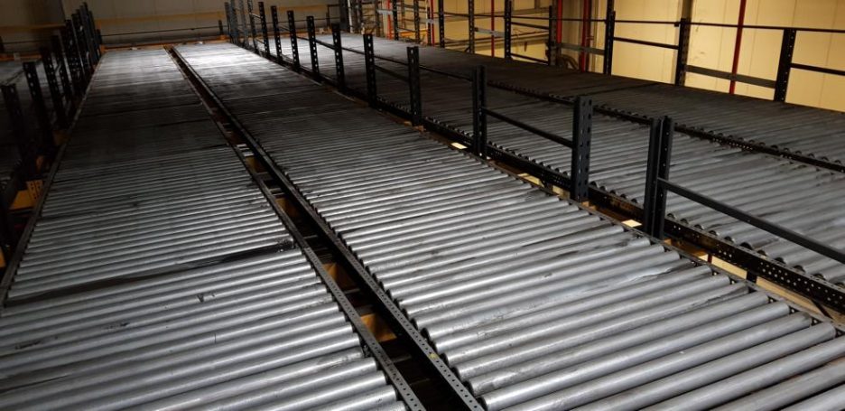 Lange, graue Metallregale in einem offenen Raum, mit gleichmäßigen Abständen zwischen den Ebenen.