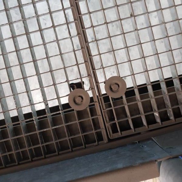 Gittertor aus braunem Metall mit zwei runden Türgriffen.