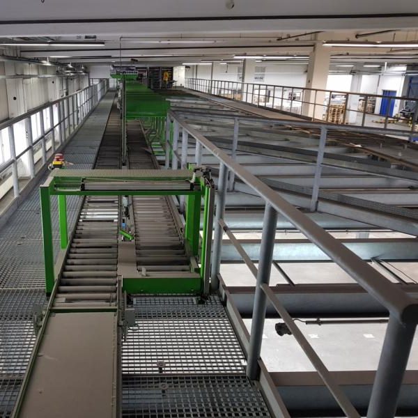 Blick auf eine industrielle Förderanlage mit grünen Elementen und Metallstruktur.