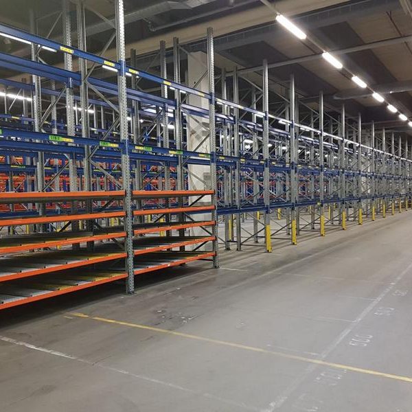 Regalbereiche in einem Lager, mit mehreren Metallregalen in Reihen angeordnet.