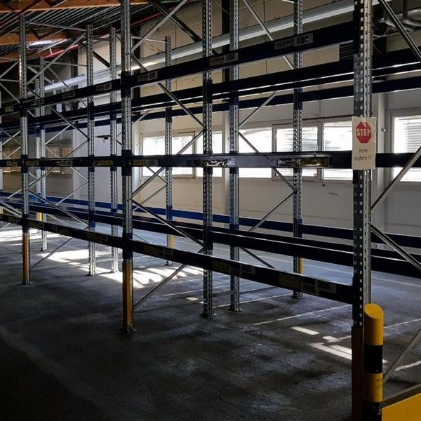 Leere Regale in einem großen, gut beleuchteten Raum mit Holzdecke.