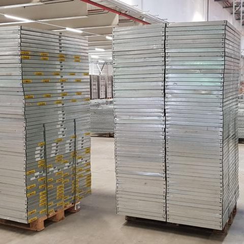 Stapeln von Metallplatten auf Paletten in einem Lager.